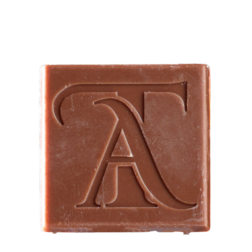 Close-up of Todd Adams Delta-8 THC chocolate bite square embossed with TA logo